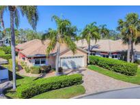 Charming single-story home with a brick driveway, well-maintained landscaping, and mature palm trees at 4406 Turnberry Ct, Bradenton, FL 34210