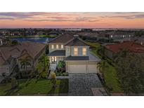 Stunning two-story home boasting manicured landscaping, a three-car garage, and picturesque water views at sunset at 5822 Title Row Dr, Bradenton, FL 34210