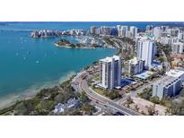 Stunning aerial view of a waterfront high-rise apartment complex with breathtaking bay views and surrounding cityscape at 770 S Palm Ave # 203, Sarasota, FL 34236