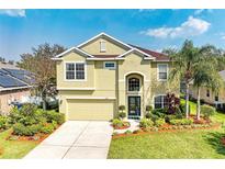 Charming two-story home featuring a well-manicured lawn and vibrant landscaping under a sunny sky at 8124 115Th E Ave, Parrish, FL 34219