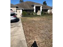 Charming one-story home with a well-manicured lawn and inviting front entrance with decorative columns at 10157 Sunburst Ct, Spring Hill, FL 34608