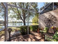 Screened patio offers peaceful lake views and comfortable seating area with stylish outdoor decor at 2123 Lynx Run, North Port, FL 34288