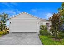Charming home featuring a two-car garage with brick paver driveway and nicely landscaped front yard at 3707 Ambersweet Crossing, Parrish, FL 34219