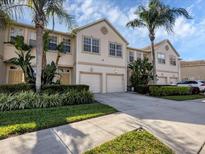 Well-maintained townhome featuring a two-car garage, lush landscaping, and a welcoming facade at 3826 Virga Blvd, Sarasota, FL 34233