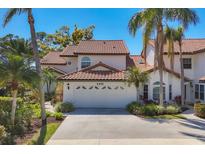 Charming home with red tile roof, a two-car garage and mature tropical landscaping around the house at 4416 Calle Serena, Sarasota, FL 34238