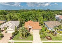 Charming home featuring a tile roof, lush landscaping, and a brick paved driveway, creating a welcoming curb appeal at 5308 88Th E St, Bradenton, FL 34211