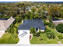Stunning home featuring lush landscaping, a screened pool, and a pristine, well-maintained exterior at 5646 Country Lakes Dr, Sarasota, FL 34243