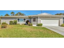 Charming single-story home with a well-maintained lawn, screened front door and a white garage at 6732 Keystone Dr, Sarasota, FL 34231