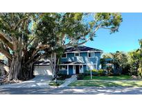 Charming two-story home with a well-maintained lawn, beautiful landscaping, and a majestic banyan tree at 7735 Westmoreland Dr, Sarasota, FL 34243