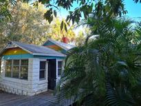 Charming cottage-style home with a mix of stone and painted siding, and lush tropical landscaping at 775 36Th S Ave, St Petersburg, FL 33705