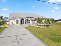Beautiful home featuring a compass design driveway, arched windows, and manicured lawn with palm trees at 9317 Saint Paul Drive, Port Charlotte, FL 33981