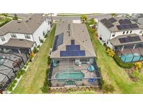 Aerial view of home with solar panels and screened pool, spa, and outdoor seating at 10179 Milky Way Cir, Sarasota, FL 34241