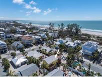 Charming coastal home near the beach with palm trees and beautiful ocean views under a sunny sky at 110 Oak Ave # A, Anna Maria, FL 34216