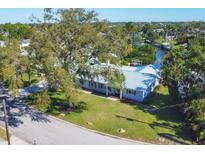 Beautiful single-story home with a metal roof, well-manicured lawn, and mature trees at 115 65Th Street Nw Ct, Bradenton, FL 34209