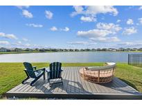 Backyard deck with lounge chairs offers serene waterfront view at 11659 Little River Way, Parrish, FL 34219