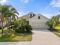Charming single-Gathering home with a two-car garage, well-manicured lawn, and lush tropical landscaping at 11742 Forest Park Cir, Bradenton, FL 34211