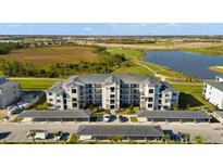 Stunning aerial view of a modern condo building overlooking a golf course and a lake at 12180 Wellen Golf St # 302, Venice, FL 34293