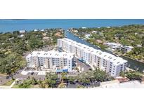 A high-angle view shows the condos and community on the waterfront, nestled among trees and a canal at 1709 N Tamiami Trl # 422, Sarasota, FL 34234