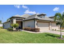 Charming single-story home showcasing a well-manicured lawn and a two-car garage at 17842 Cherished Loop, Bradenton, FL 34211