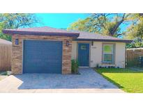 Charming single-story home with a blue front door, stone accents, and a well-manicured lawn at 2255 Chester Ave, Sarasota, FL 34234
