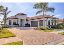 Beautiful single-story home showcasing a brick driveway, lush landscaping, and an attached two-car garage at 525 Maraviya Blvd, Nokomis, FL 34275