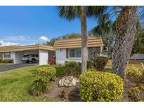 Charming single-story home features a well-manicured lawn, carport, and stone accents at 5571 Riverbluff Cir # V1, Sarasota, FL 34231
