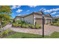 Charming exterior with a brick driveway, manicured landscaping, and a welcoming entrance at 6070 Mesa Gln, Bradenton, FL 34203