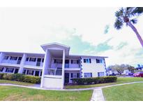 Two story condo building showing balconies, lawn, shrubbery, sidewalk and a palm tree at 105 47Th Avenue W Dr # 377, Bradenton, FL 34207