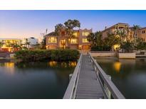 A waterfront property features a private dock and a three-story house with large windows and attached garages at 1364 Point Crisp Rd, Sarasota, FL 34242