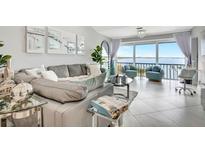 Modern living room features views of the ocean, stylish furniture, and lots of natural light at 1602 Stickney Point Rd # 404, Sarasota, FL 34231