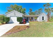 Charming single-story home featuring a well-maintained lawn and a quaint front porch entrance at 1761 Shevlin St, North Port, FL 34286