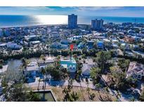 Aerial view of home with beach and city in the background, showing proximity to coastal amenities at 288 Island Cir, Sarasota, FL 34242