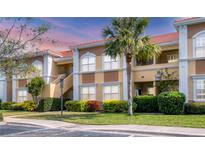 Inviting two-story condo featuring manicured landscaping, neutral color palette, and a terracotta tile roof at 1110 Villagio Cir # 103, Sarasota, FL 34237