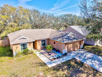 Aerial view of the home, showcasing the driveway, garage, and colorful, landscaped front yard at 11213 2Nd E Ave, Bradenton, FL 34212