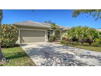 Charming home featuring lush landscaping and a spacious driveway leading to an attached two-car garage at 129 Wayforest Dr, Venice, FL 34292