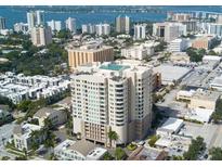 An aerial view of a high-rise building with a rooftop pool in a coastal city at 1771 Ringling Blvd # 902, Sarasota, FL 34236