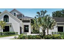 Elegant two-story home with manicured landscaping, a dark roof, and modern architecture at 329 Bird Key Dr, Sarasota, FL 34236