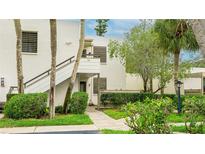 Two-story condo featuring lush landscaping, private entrances, and a textured facade at 333 Springdale Dr # 333, Bradenton, FL 34210