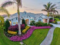 Beautiful single-Gathering home with lush landscaping and a well-manicured lawn and palm trees at 556 Regatta Way, Bradenton, FL 34208