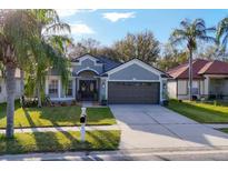 Charming home features a well-maintained lawn and a two-car garage at 7135 Royal George Ct, Wesley Chapel, FL 33545