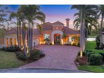Elegant home featuring lush landscaping, a brick driveway, and barrel tile roof at 7327 Greystone St, Lakewood Ranch, FL 34202