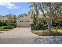 Lovely home features a paved driveway, tile roof, lush landscaping, and an attached two-car garage at 866 Placid Lake Dr, Osprey, FL 34229
