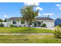 Charming single-story home with lush green lawn and mature landscaping on a beautiful sunny day at 8719 Gaillard Ave, North Port, FL 34287