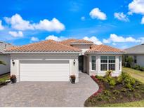 Charming single-story home with a tile roof, paver driveway, and beautifully landscaped front yard at 10240 Beach Dune Dr, Englewood, FL 34223