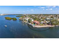 Stunning waterfront home with a pool and private dock, surrounded by lush landscaping at 1444 Ridgewood Ln, Sarasota, FL 34231