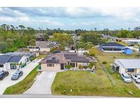 Charming single-story home featuring a well-manicured lawn and solar panels on the roof at 392 Yeager St, Port Charlotte, FL 33954