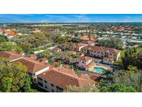 An aerial view shows the beautiful community with a pool, landscaping, and parking at 3958 Mediterranea Cir # 411, Sarasota, FL 34233