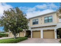 Tan condo building with a light brown brick parking area and a large green tree in the front at 4210 Overture Cir, Bradenton, FL 34209