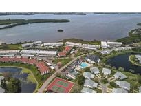 Stunning aerial view showcasing the waterfront community, pool, tennis courts, and lush landscaping at 4753 Independence Dr, Bradenton, FL 34210