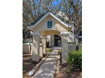 Inviting entrance to the building, featuring a covered walkway, lush landscaping, and well-maintained architecture at 5168 Northridge Rd # 102, Sarasota, FL 34238